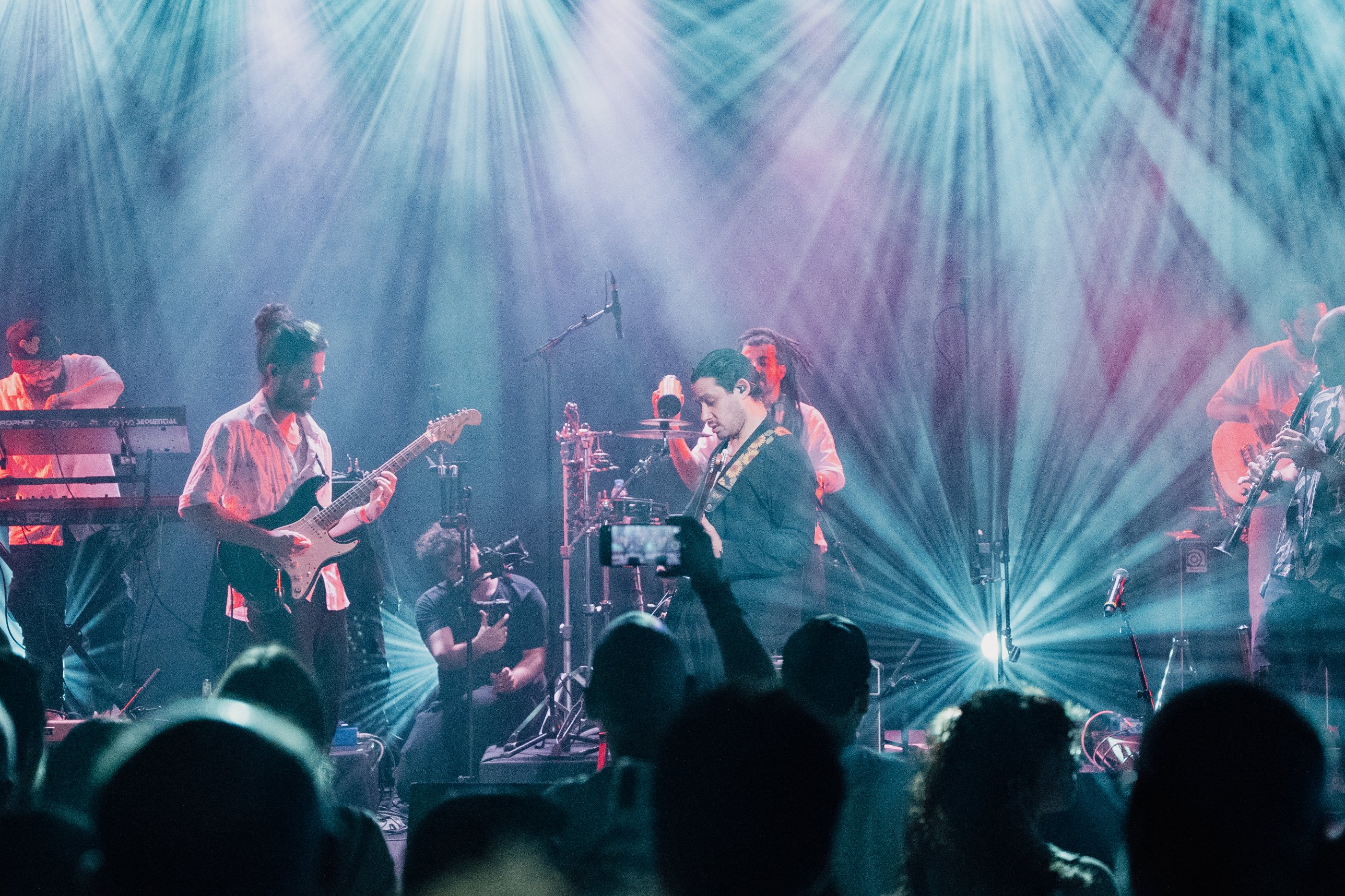 YUZ on guitar with the band under stage lights