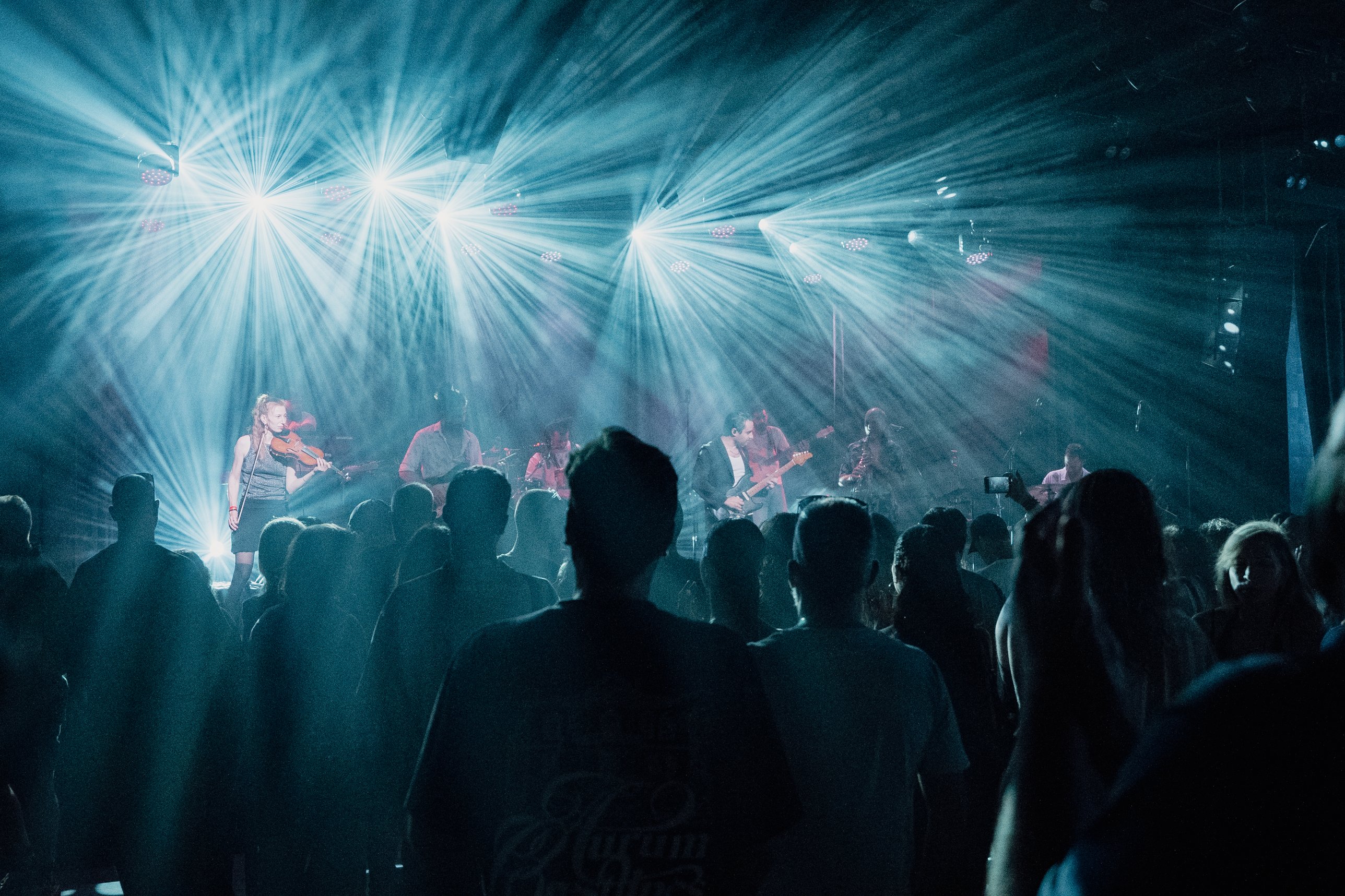 Light rays over the band and a packed room